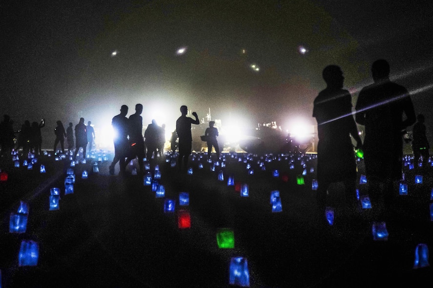 Soldiers walking across a field of 6,800 memorial lights.