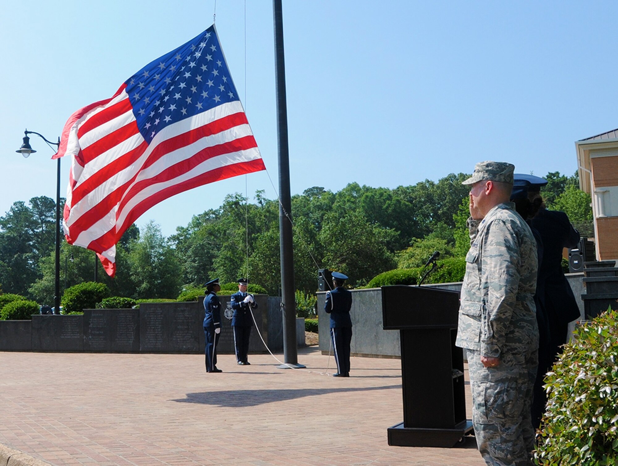 Team BLAZE Honor Guardsmen lower the U.S. flag during the Memorial Day Retreat Ceremony May 26 at Columbus Air Force Base, Mississippi. While being lowered, Airmen and civilian attendees stand at attention and salute or render their respects in honor of the men and women who died while serving in the U.S. military. (U.S. Air Force photo/ Melissa Doublin)