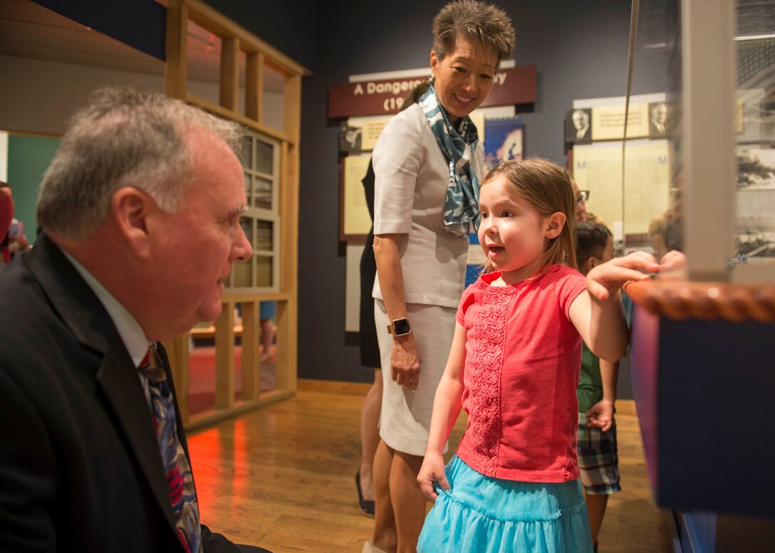 Joseph M. Judge, deputy director of Hampton Roads Naval Museum, explains an exhibit to a child who attended the launch of Blue Star Museums at the Hampton Roads Naval Museum in Norfolk, Va., May 26, 2016. Blue Star Museums is a collaboration among the National Endowment for the Arts, Blue Star Families, the Department of Defense and more than 2,000 museums across America to offer free admission to the nation's active duty military members and their families from Memorial Day through Labor Day. Navy photo by Petty Officer 3rd Class Amy M. Ressler