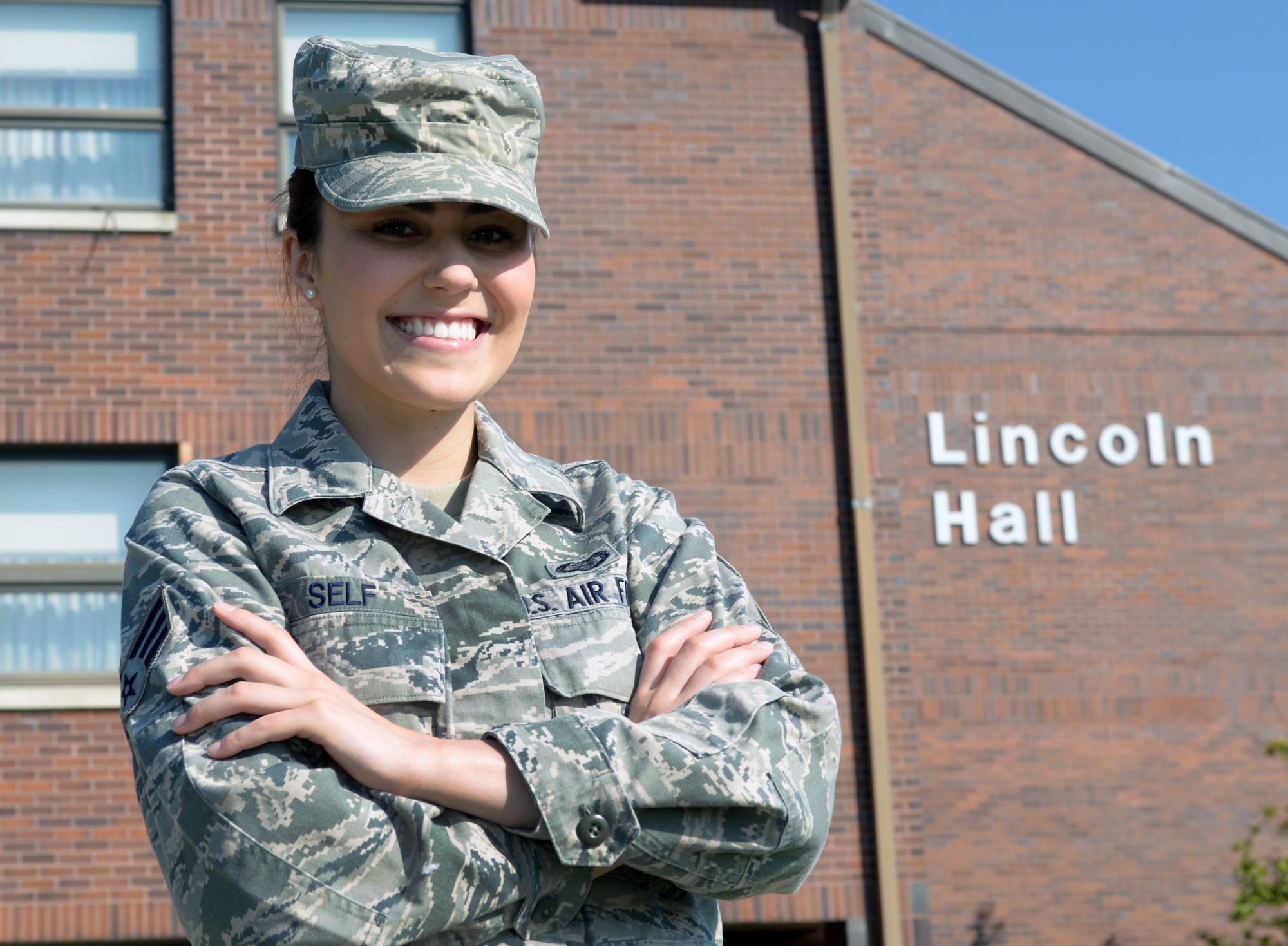 Senior Airman Arielle Self, 432nd Attack Squadron mission intelligence coordinator and Dorm Council president, stands in front of Lincoln Hall at Ellsworth Air Force Base, S.D., May 17, 2016. Self brought up the idea of the Prevention Dormitory Advocate team as a new way to provide Airmen residing in the dorms a way to seek help, acting as liaisons between Airmen and the Sexual Assault Response Coordinator. (U.S. Air Force photo by Airman Donald Knechtel/Released) 
