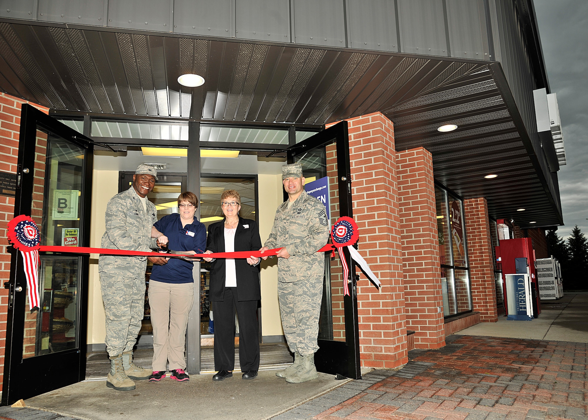 (From left) Col. Rodney Lewis, 319th Air Base Wing commander; Shawna Turner, Grand Forks Express manager, Susan Humphress, Exchange main store manager and Chief Master Sgt. Todd Krulcik, 319th ABW command chief, prepare to cut the ribbon during the Express reopening ceremony May 23, 2016 on, Grand Forks Air Force Base, N.D. The Grand Forks AFB Express has been renovated with new floors, healthier food options and a new kitchen for a future food program.  (U.S. Air Force photo/Senior Airman Xavier Navarro)