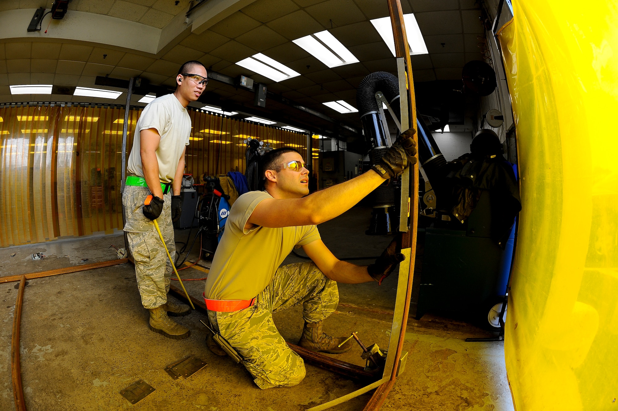 Staff Sgt. Armand Guting, left, and Senior Airman Andrew Flanagan, right, aircraft metals technology technicians with the 6th Maintenance Squadron, measure to find the location for a support beam on the paint rack at MacDill Air Force Base, Fla., May 20, 2016. Once the rack is complete, it will function like a clothing rack and have parts hanging off the framed roof. (U.S. Air Force photo by Airman 1st Class Mariette Adams)