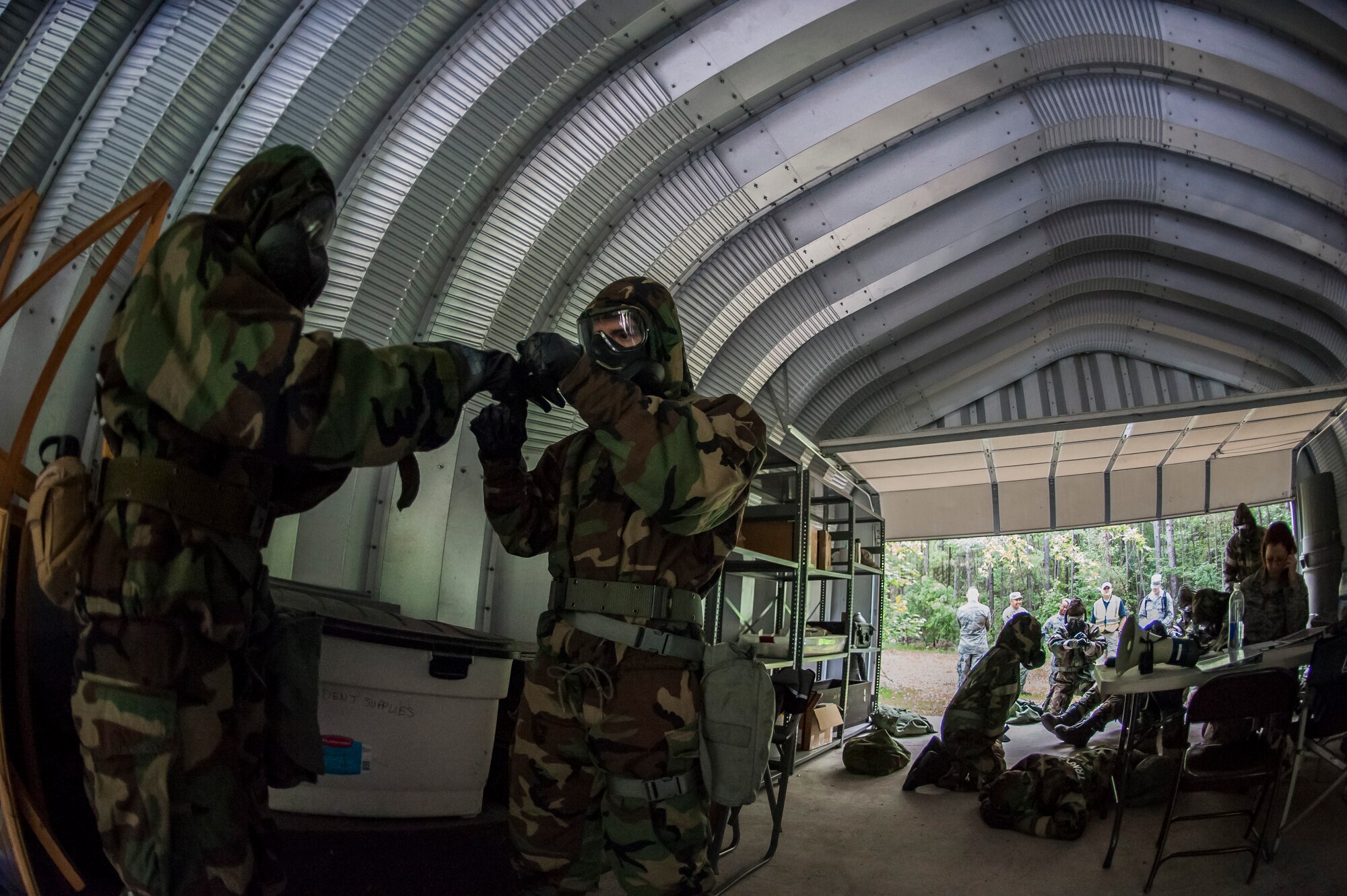 Airmen help each other put on protective gear during a chemical, biological, radiological, nuclear and explosives drill as part of Exercise Crescent Reach 16, May 19, 2016, at Joint Base Charleston, S.C. The exercise tested JB Charleston’s ability to launch a large aircraft formation and mobilize a large amount of cargo and passengers. (U.S. Air Force photo/Staff Sgt. Jared Trimarchi)