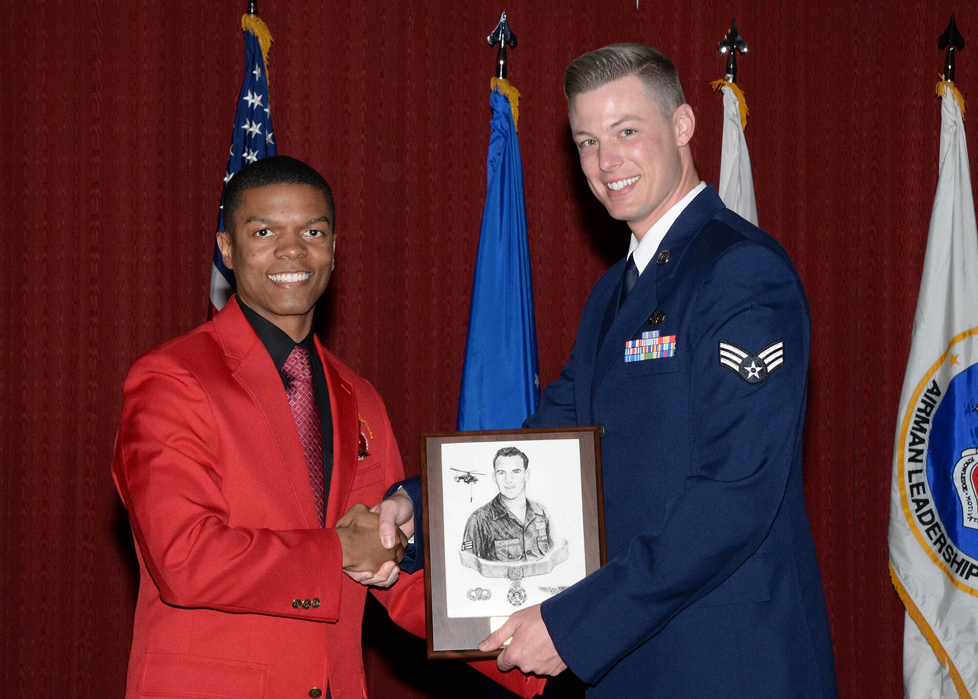 First Lt. Yemoni Huguely, left, representing the Charles E. McGee Chapter of the Tuskegee Airmen, presents the Academic Achievement Award to Senior Airman Michael Horn, C3I and Networks Directorate, during the Airman Leadership School graduation ceremony May 20. The award is presented to the top student who achieves the highest summative scores throughout the class and who displays all characteristics of an effective leader. (U.S. Air Force photo by Linda LaBonte Britt)