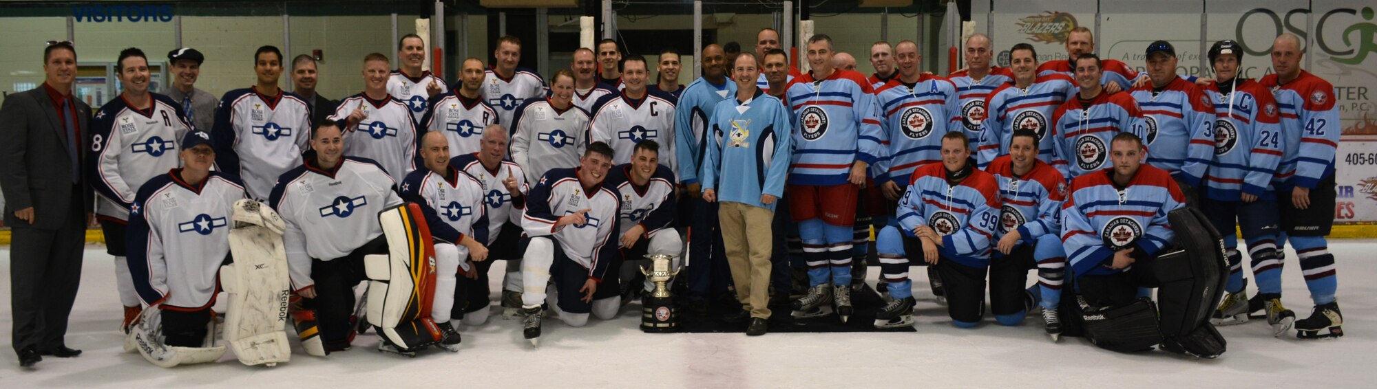 Members of the 552nd Air Control Wing and 552nd ACW Canadian Detachment at Tinker Air Force Base pose for a group photo at the conclusion of the 8th Annual Can/Am Cup hockey game May 20 at the Blazers Ice Centre in Oklahoma City. The Americans won the game, 9-5, to reclaim the cup. (Air Force photo by Darren D. Heusel/Released)