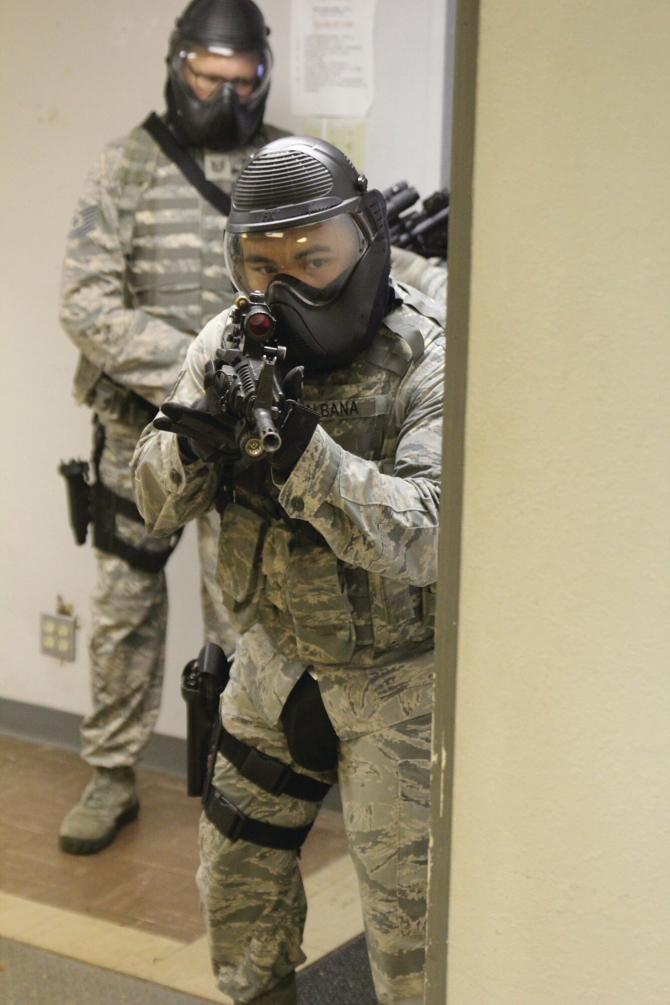Staff Sgt. Bon Albana, rear, and Tech. Sgt. Justin Ayers demonstrate building clearing tactics at a simulated active shooter event during National Police Week. The 72nd Security Forces Squadron sponsored events May 16-20 that included weapons displays and a memorial service for officers killed in the line of duty. (Air Force photo by Tech. Sgt. Timothy Nesbitt/Released)