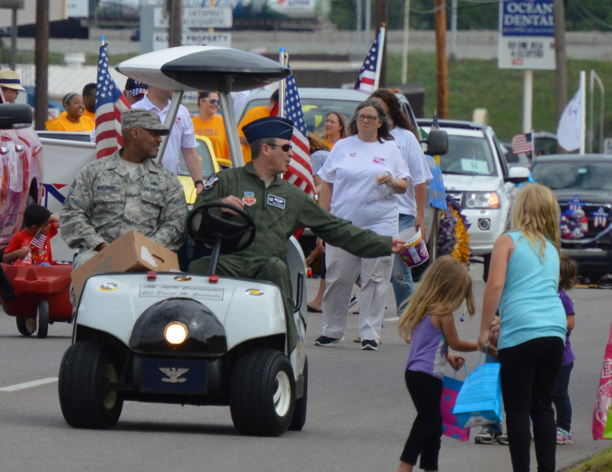 Col. David Gaedecke, 552nd Air Control Wing commander, and 552nd ACW Command Chief Master Sgt. Avery Woodridge hand out candy along the parade route. (Air Force photo by April McDonald/Released)