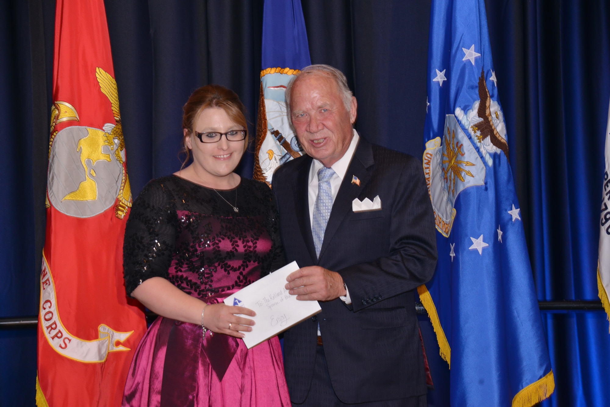 Sherman McCorkle, Kirtland Partnership Committee, presents Spouse of the Year Award to Savannah Hewett. Hewett, wife of  wife of Tech. Sgt. Frank Hewett of the 377th Security Forces Squadron, was selected for her volunteerism and contributions to the community. (Photo by Dennis Carlson)