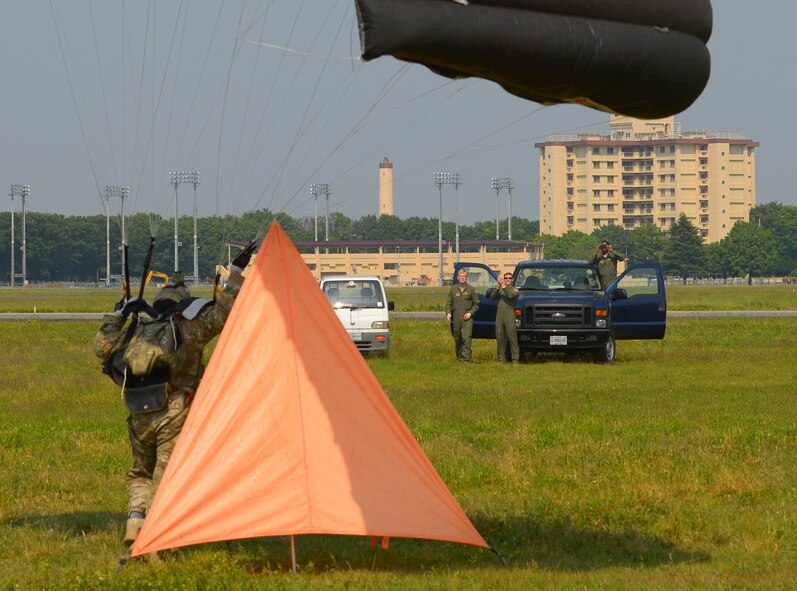 Tech. Sgt. Benjamin Johnis, 374th Operations Support Squadron NCO in charge of Survival, Evasion, Resistance and Escape operations, touches down in the drop zone at Yokota Air Base, Japan, May 23, 2016. Support from drop zone coordinators is important for making sure that a parachutist’s drop zone is clear of any obstructions such as people, vehicles and aircraft that could interfere with a safe landing. (U.S. Air Force photo by Airman 1st Class Elizabeth Baker/Released)