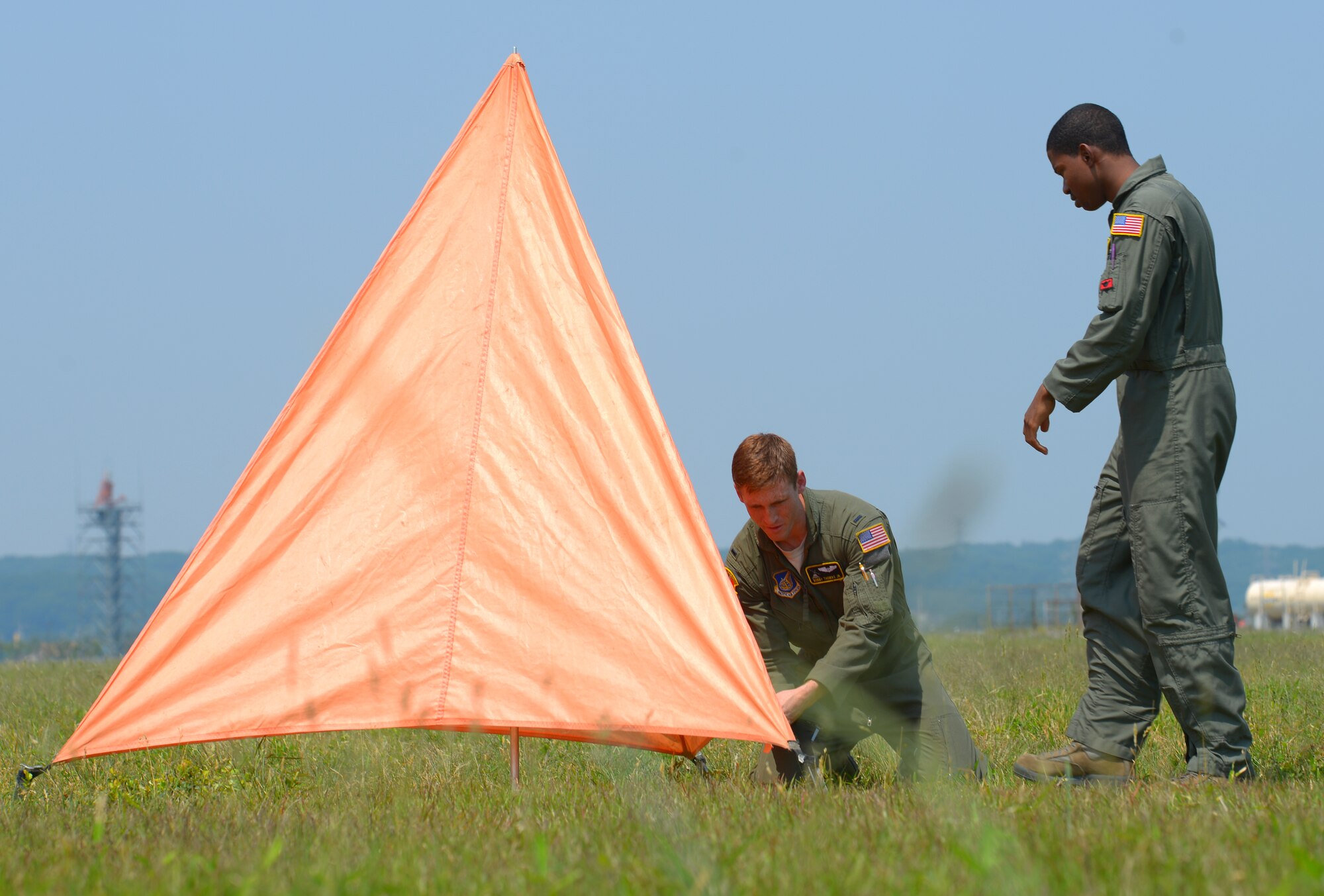2nd Lt. Bobby Thomas Jr., 36th Airlift Squadron C-130 Hercules navigator, sets up a raised angle marker with Senior Airman Adrian Robinson, 36 AS C-130H loadmaster, at Yokota Air Base, Japan, May 23, 2016. While coordinating the drop zone for a personnel drop, Thomas is responsible for setting up the marker which guides personnel to the ground ensuring that jumpers are able to train safely. (U.S. Air Force photo by Airman 1st Class Elizabeth Baker/Released)