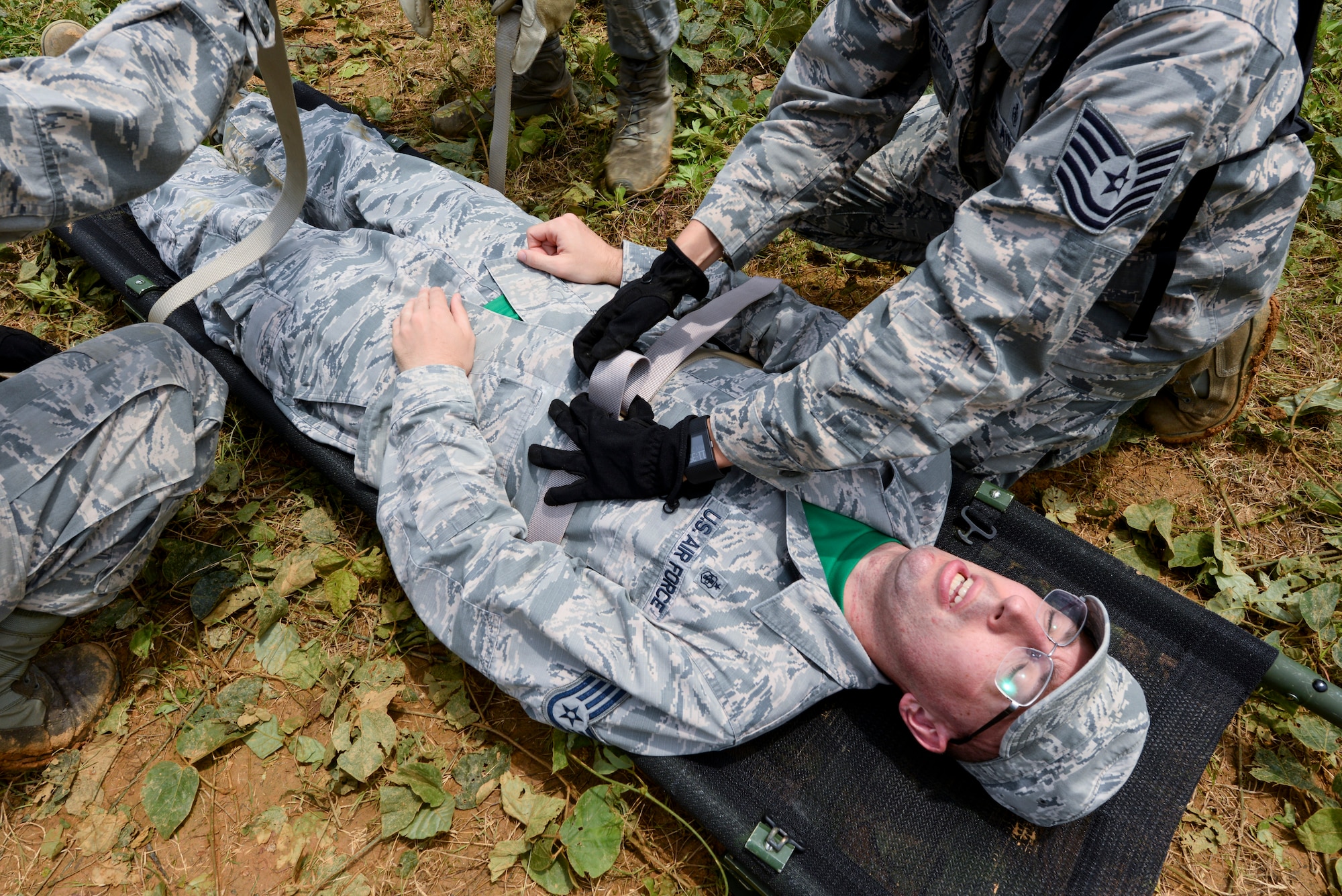Staff Sgt. Paul Fox, 18th Aerospace Medicine Squadron administration services NCO in charge, is harnessed to a stretcher as part of a field training day May 20, 2016, at Area One, Kadena Air Base Japan. Airmen from public health, bioenvironmental, flight medicine, aeromedical staging flight, optometry, aerospace physiology, and theater preventive medicine led hands-on training activities in order to better prepare establishing and supporting an operational site in a deployed environment. (U.S. Air Force photo by Senior Airman John Linzmeier) 