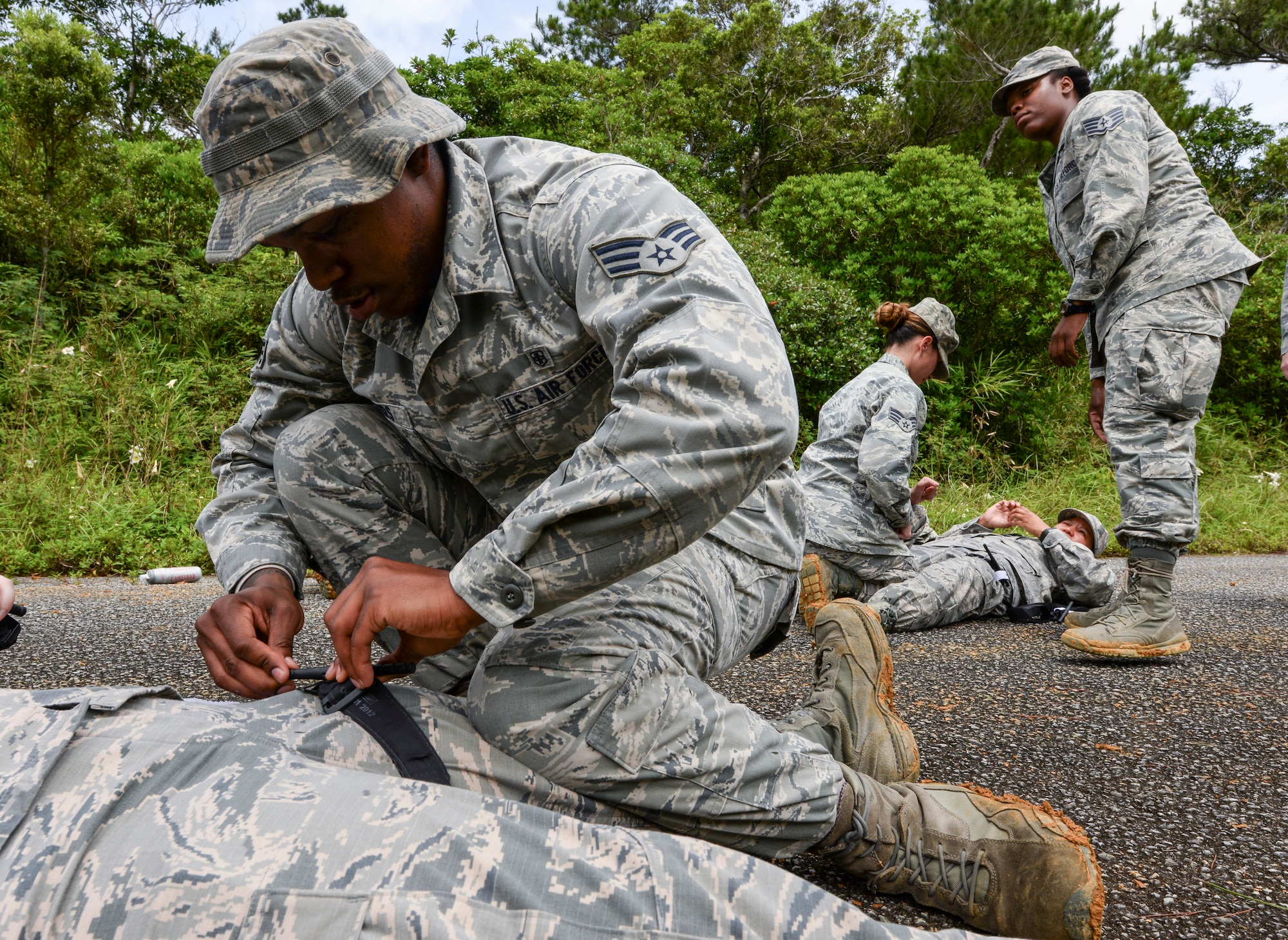 Senior Airman Aaron Rodgers 18th Aerospace Medicine Squadron bioenvironmental technician, fastens a tourniquet on his wingman as part of a field training day May 20, 2016, at Area One, Kadena Air Base Japan. Participants of the Preventative Aerospace Medicine Convention practiced administering various self-aid and buddy care scenarios, preparing them to stop rapid bleeding at a moment’s notice. (U.S. Air Force photo by Senior Airman John Linzmeier) 