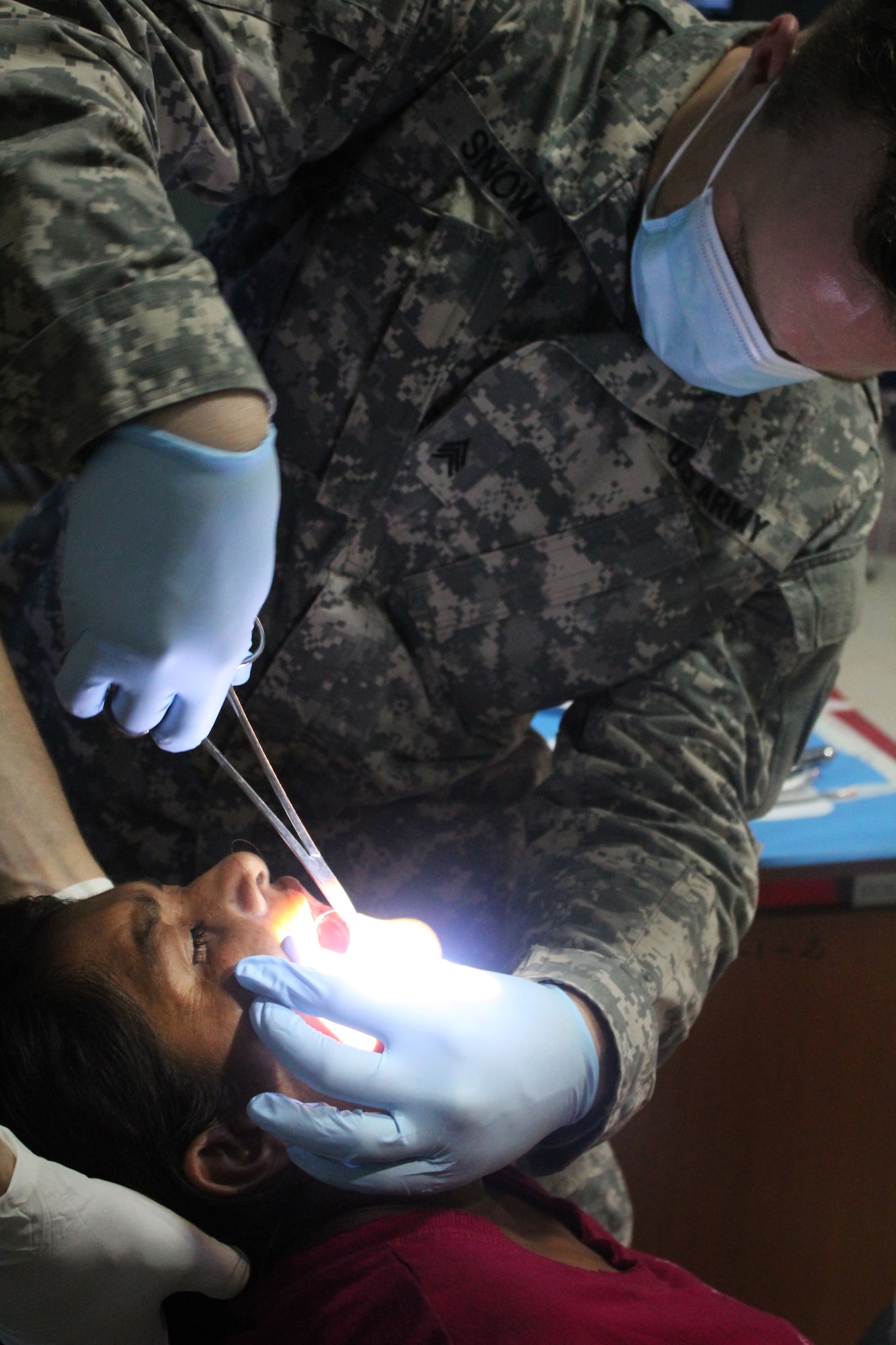 U.S. Army Sgt. Shelby Snow applies sutures to a Nicaraguan woman after having several tooth extractions during a Joint Task Force-Bravo-led Medical Readiness Training Exercise in Alamikamba, Nicaragua, May 18, 2016. The dental services team saw a total of 135 patients, most of whom required more than one extraction. Many residents of Alamikamba suffer from decaying teeth due to the bad water conditions and lack of dental care in the area. (U.S. Army photo by Maria Pinel)    