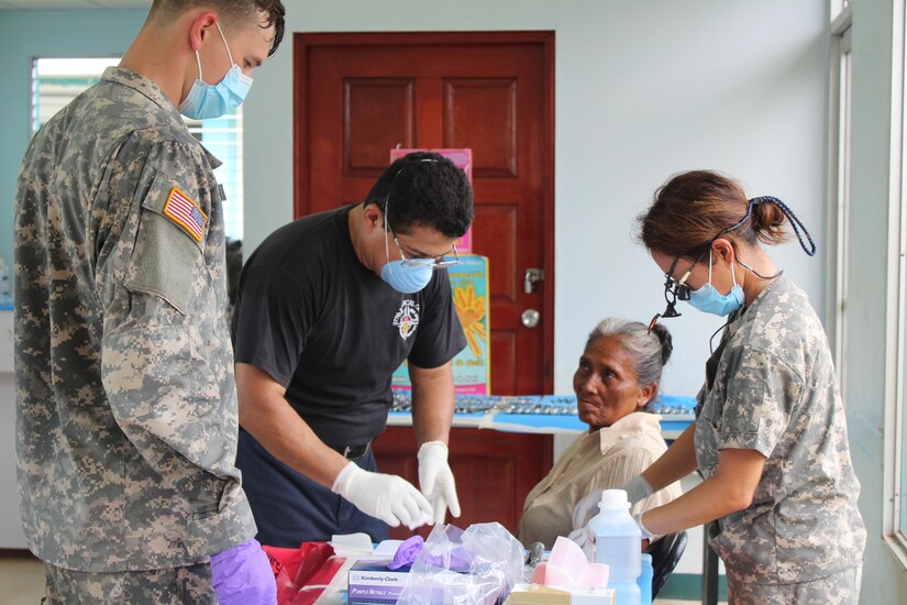 U.S. Army Spc. Tyler Novich, Honduran Dr. Wilmer Amador, and U.S. Army Maj. Margaret Novicio, Joint Task Force-Bravo Medical Element dental services, prepare to perform several tooth extractions on an elderly Nicaraguan woman during a Medical readiness Training Exercise in Alamikamba, Nicaragua, May 18, 2016. Several patients suffered from decaying teeth due to the bad water conditions and lack of preventive dental care in the area. Dental care is one of several services provided by the Medical Element, in cooperation with Nicaraguan Ministry of Health representatives. (U.S. Army photo by Maria Pinel)