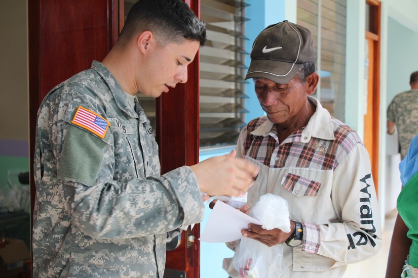 U.S. Army Cpl. Anthony Vargas, Joint Task Force-Bravo Joint Security Forces, facilitates translation between the pharmacy team and Nicaraguan nationals while handing out prescribed medications to patients during a Joint Task Force-Bravo-led Medical Readiness Training Exercise, May 19, 2016, in Alamikamba, Nicaragua. Free medication was provided for all those that visited the MEDRETE site after consultations with medical providers. (U.S. Army photo by Maria Pinel)   
