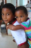 Un niño carga a su hermana mientras su madre recibe atención médica básica durante un Ejercicio de Entrenamiento de Respuesta Medica, dirigido por el Elemento Medico de la Fuerza de Tarea Conjunta-Bravo el 18 de mayo del 2016, en Alamikamba, Nicaragua. Muchos de los niños en la Costa Misquita de Nicaragua sufren de desnutrición y falta de vitaminas. Durante el ejercicio, se les brindo medicina preventiva a los adultos y niños en un kit preventiva que recibieron previo a las consultas médicas. (Fotografía del Ejército de los EE.UU. por Maria Pinel)