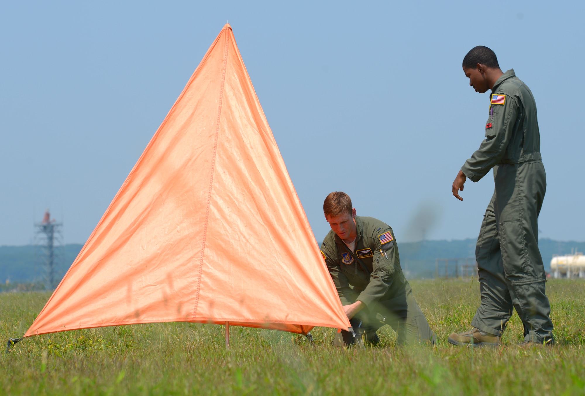 2nd Lt. Bobby Thomas Jr., 36th Airlift Squadron C-130 Hercules navigator, sets up a raised angle marker with Senior Airman Adrian Robinson, 36 AS C-130H loadmaster, at Yokota Air Base, Japan, May 23, 2016. While coordinating the drop zone for a personnel drop, Thomas is responsible for setting up the marker which guides personnel to the ground ensuring that jumpers are able to train safely. (U.S. Air Force photo by Airman 1st Class Elizabeth Baker/Released)