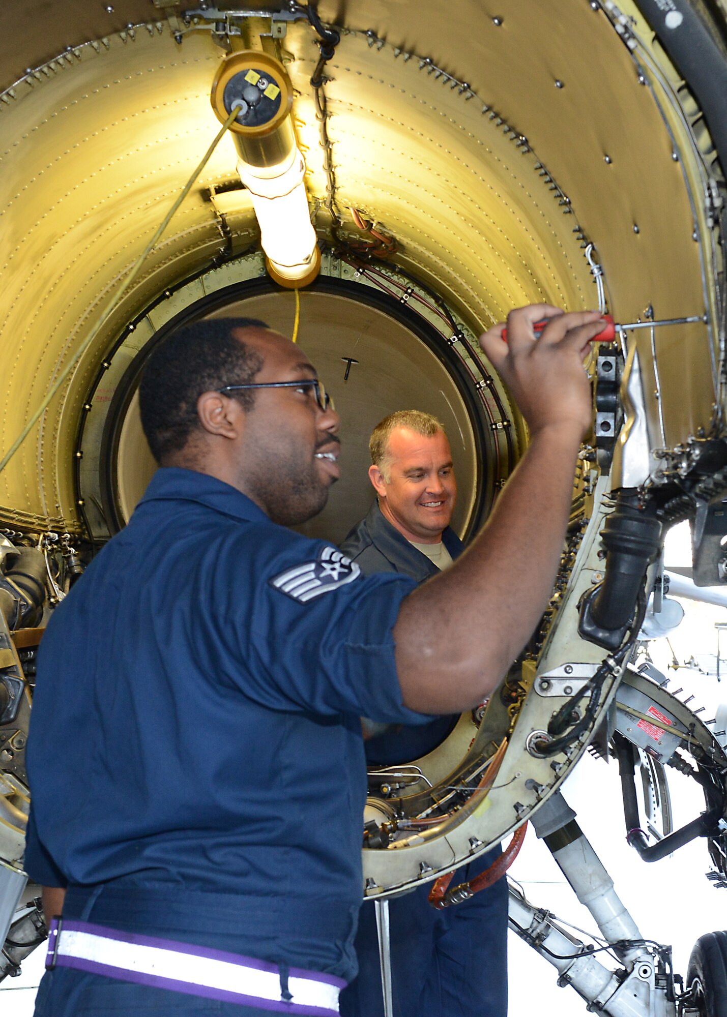 Master Sgt. Adam Oltjenbruns, an Air Force Reserve volunteer from Hill Air Force Base, Utah, works with Staff Sgt. Eric Gordon of the 412th Aircraft Maintenance Squadron to complete an F-16 engine bay inspection. The Reservists are here to augment Edwards F-16 support for KC-46 Pegasus testing. (U.S. Air Force photo by Kenji Thuloweit.)