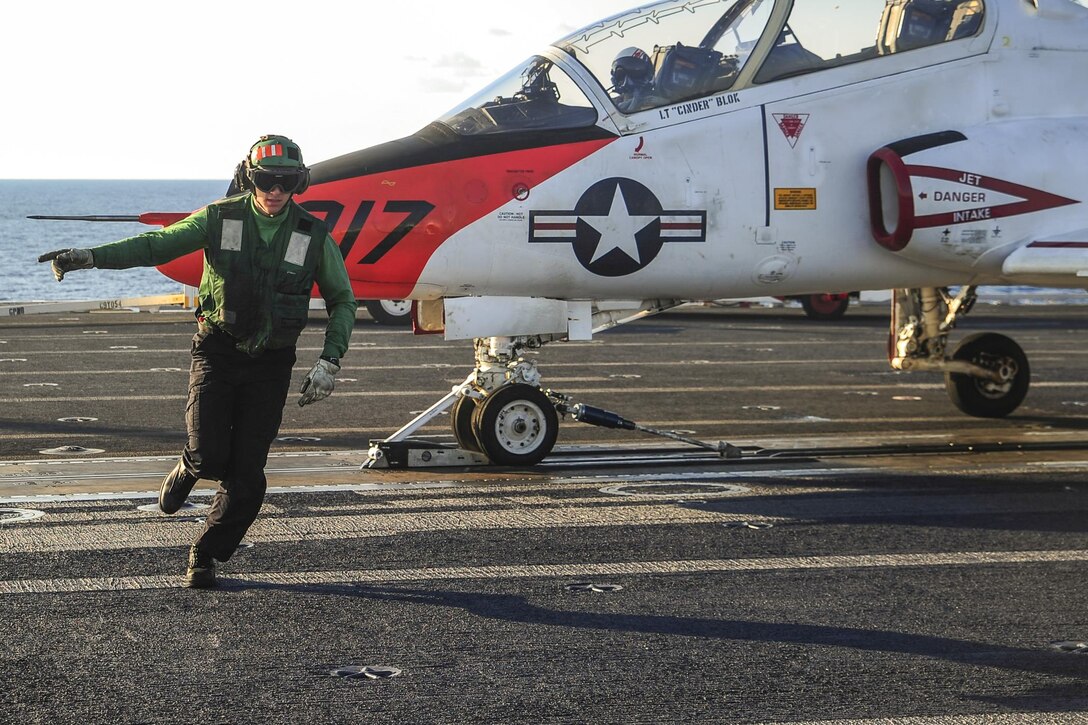 Navy Petty Officer Alexander Hogan runs off the runway after ensuring a T-45C Goshawk is ready for launch on the flight deck of the aircraft carrier USS George Washington in the Atlantic Ocean, May 23, 2016. The Washington is conducting carrier qualifications. Navy photo by Seaman Clemente A. Lynch