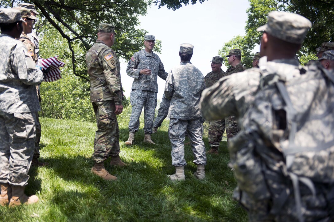 Army Chaplain (Col.) Gary R. Studniewski, center, speaks to soldiers before they participate in “Flags In” at Arlington National Cemetery in Arlington, Va., May 26, 201. The soldiers placed flags at each headstone in the cemetery except at Chaplains Hill, where only Army chaplains place flags. Gary R. Studniewski is command chaplain for Joint Force Headquarters-National Capital Region and U.S. Army Military District of Washington. Army photo by Rachel Larue