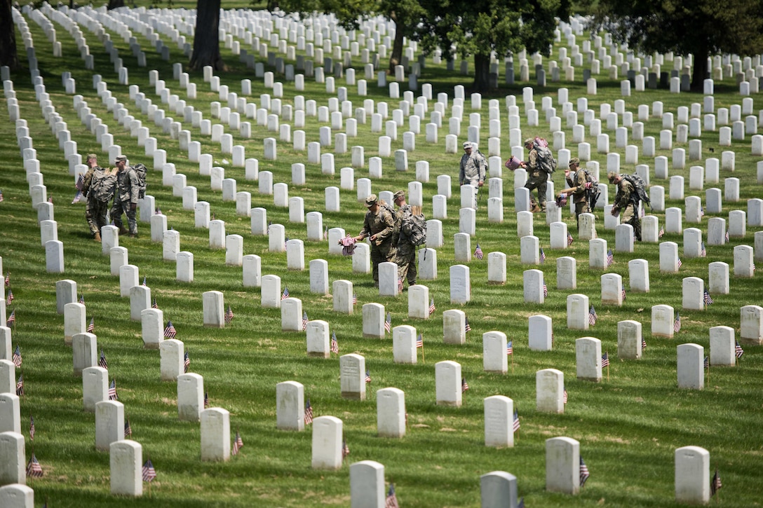 Soldiers place American flags in front of headstones during "Flags In" at Arlington National Cemetery in Arlington, Va., May 26, 2016. The soldiers are assigned to the 3rd U.S. Infantry Regiment, known as "The Old Guard." Soldiers assigned to the regiment placed approximately 230,000 flags during the event, with each of the cemetery's headstones receiving a flag for the Memorial Day holiday. Army photo by Rachel Larue