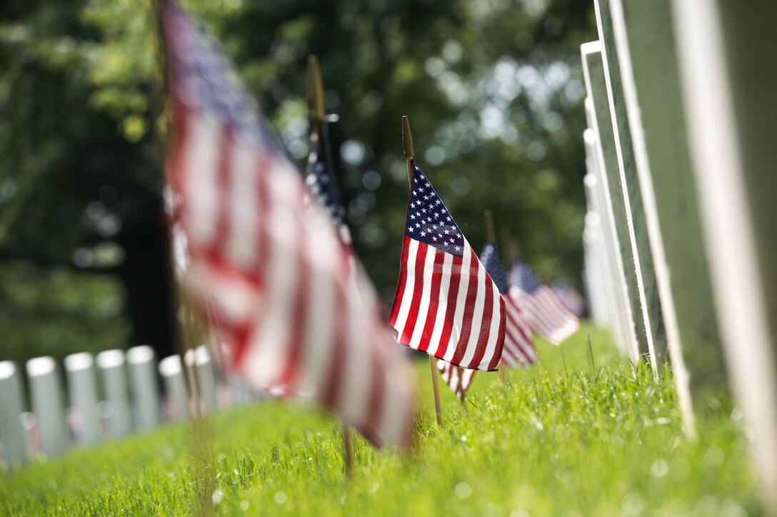 American flags placed during "Flags In" stand in front of headstones at Arlington National Cemetery in Arlington, Va., May 26, 2016. Army photo by Rachel Larue