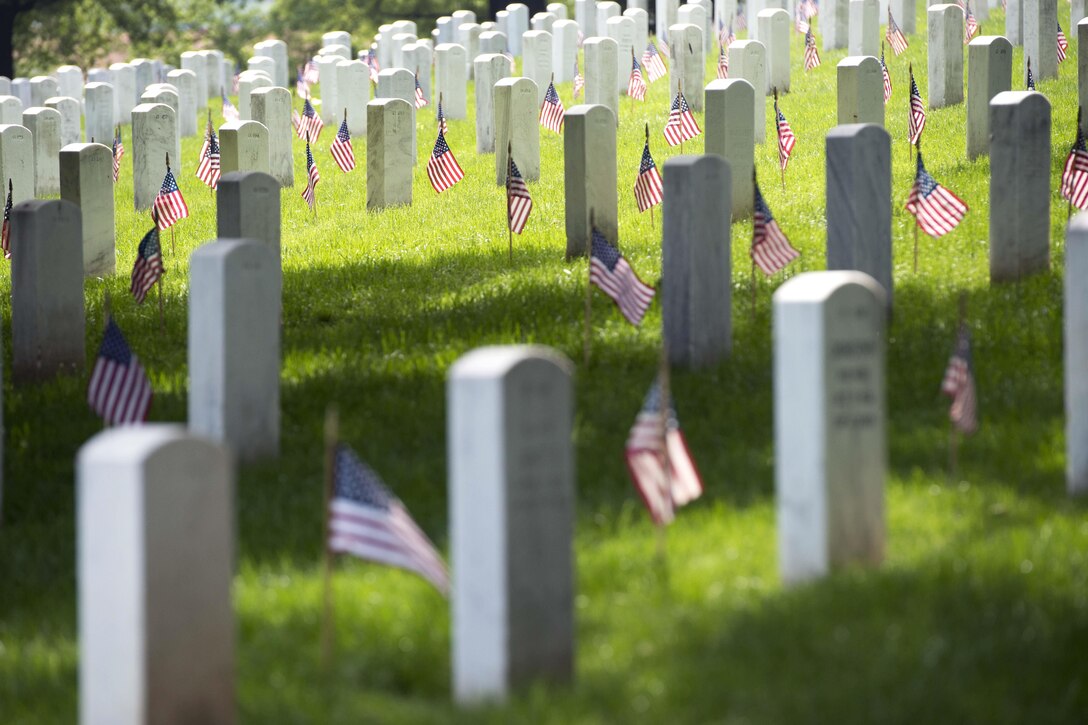 American flags placed during "Flags In" stand in front of headstones at Arlington National Cemetery in Arlington, Va., May 26, 2016. Army photo by Rachel Larue