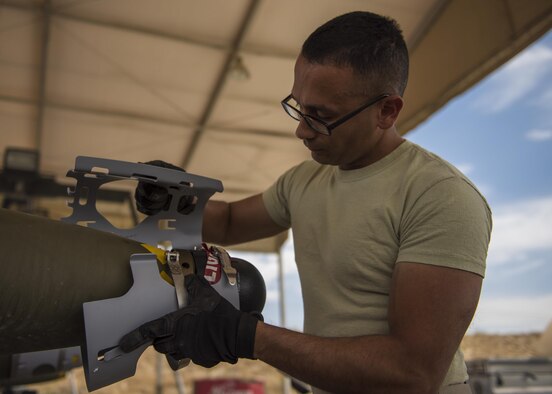 Staff Sgt. Alejandro Medina, 455th Expeditionary Maintenance Squadron Munitions Flight, munitions system specialist, helps build a GBU-54 munition at Bagram Airfield, Afghanistan, May 26, 2016. Munitions systems specialists handle, store, transport, arm and disarm weapons systems. (U.S. Air Force photo by Senior Airman Justyn M. Freeman)