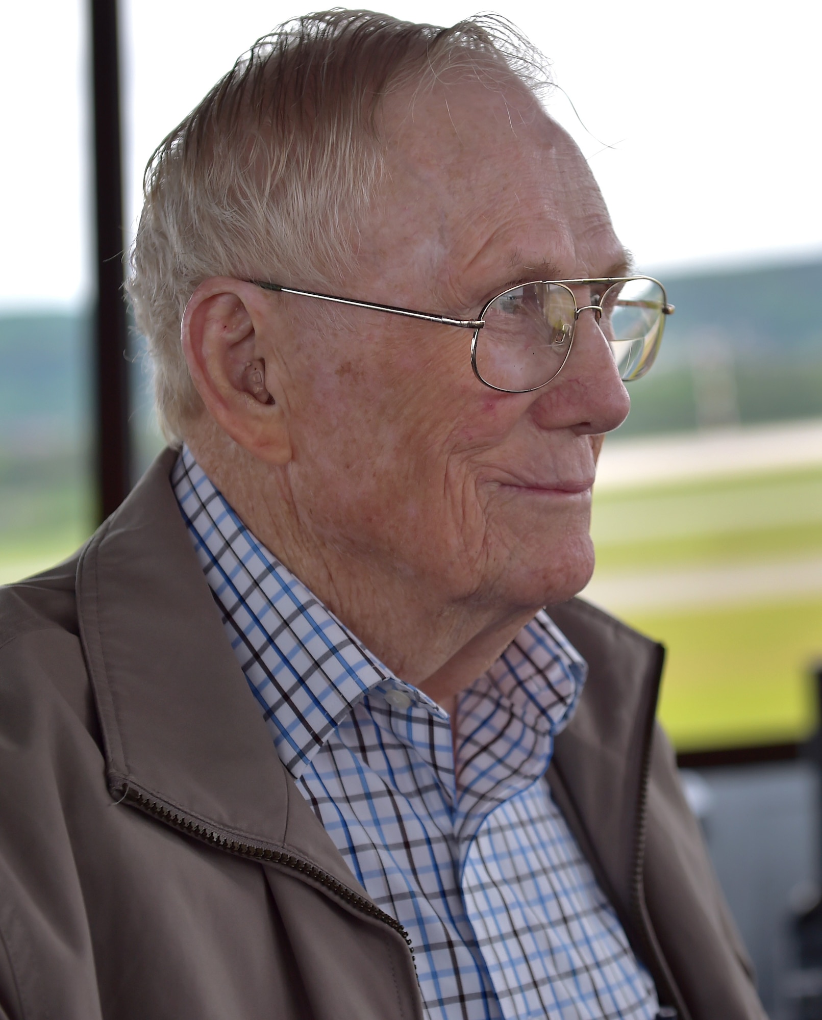 U.S. Air Force Chief Master Sgt. (Retired) Kenneth Andrews looks out the window of Ramstein’s Air Traffic Control tower during a visit, May 24, 2016, Ramstein Air Base, Germany. Andrews, along with his grandson, Lt. Col. Michael Andrews, visited to the tower and the Airmen working that day to speak with them about his 30-year AF career as an Air Traffic Controller. Andrews spent three years of his AF career at Ramstein (1959-1962) and was serving on the installation during significant historical points in history like the Cold War and construction of the Berlin Wall.