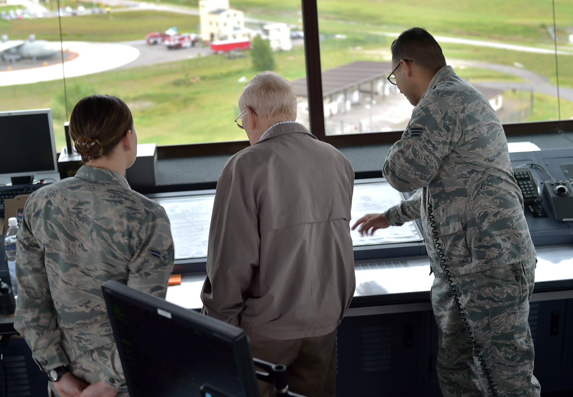 U.S. Air Force Chief Master Sgt. (Retired) Kenneth Andrews meets with several Ramstein Airmen during a visit to the Air Traffic Control tower, May 24, 2016, Ramstein Air Base, Germany. Andrews had the opportunity to speak to the controllers on duty that day and share with them his background as a 30-year retired traffic controller. Andrews entered the AF in 1947 and retired in 1977 after having served in several combat roles during his military career.