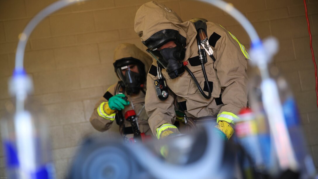 Marines with the Aircraft Rescue and Firefighting hazardous material team assess the contaminated area during a Chemical, Biological, Radiological, Nuclear and High-Yield Explosives exercise at the gas chamber aboard Marine Corps Air Station Miramar, Calif., May 18, 2016. The exercise revolved around PMO, the Miramar Fire Department, Explosive Ordnance Disposal, and Aircraft Rescue and Firefighting working together to identify and eliminate the threat of a simulated clandestine drug lab. 