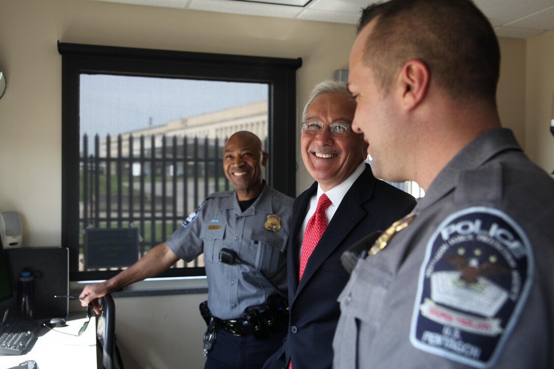 Pentagon Force Protection Agency Director Steven E. Calvery, center, visits with two of his officers, Zanda Bell, left, and Robert Jones, in a security booth, April 19, 2016. Officers in Pentagon security checkpoints booths are responsible for controlling vehicle access onto the reservation. DoD photo by Shannon Giles