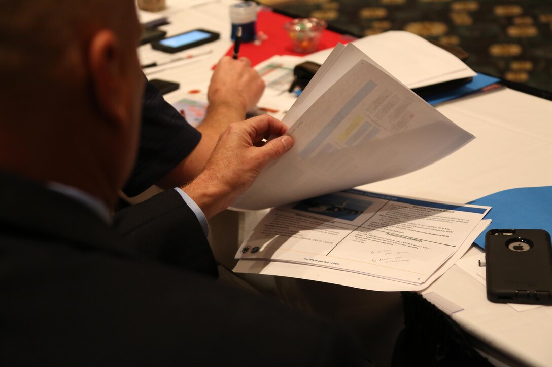 Attendees sit through an opening brief during the 45th Annual Marine Corps Aviation Association Symposium and Marine Aviation Summit at New Bern, N.C., May 17, 2016. Hundreds of naval aviators gathered at the convention center for the opening brief to the weeklong event. Senior leaders gathered to discuss the future of Marine Corps aviation and the steps the Corps is taking to reach its set goals. (U.S. Marine Corps photo by Cpl. N.W. Huertas/Released)