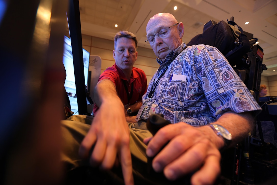 Mark Bosley, left, explains the controls of the Lockheed Martin  F-35 demonstrator to John Hudson during the 45th Annual Marine Corps Aviation Association Symposium and Marine Aviation Summit at New Bern, N.C., May 17, 2016. Hundreds of naval aviators gathered at the convention center for the opening brief to the weeklong event. Senior leaders gathered to discuss the future of Marine Corps aviation and the steps the Corps is taking to reach its set goals. Bosley is a Lockheed Martin F-35 demonstrator instructor pilot and Hudson is a retired U.S. Marine and award nominee at the event. (U.S. Marine Corps photo by Cpl. N.W. Huertas/Released)