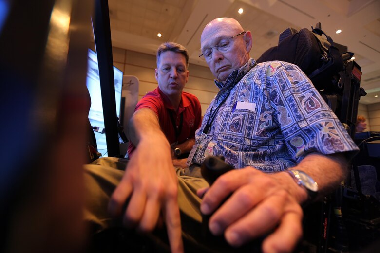 Mark Bosley, left, explains the controls of the Lockheed Martin  F-35 demonstrator to John Hudson during the 45th Annual Marine Corps Aviation Association Symposium and Marine Aviation Summit at New Bern, N.C., May 17, 2016. Hundreds of naval aviators gathered at the convention center for the opening brief to the weeklong event. Senior leaders gathered to discuss the future of Marine Corps aviation and the steps the Corps is taking to reach its set goals. Bosley is a Lockheed Martin F-35 demonstrator instructor pilot and Hudson is a retired U.S. Marine and award nominee at the event. (U.S. Marine Corps photo by Cpl. N.W. Huertas/Released)