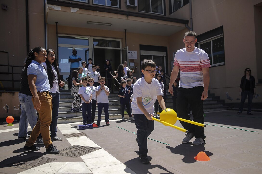 Marines and sailors with Special Purpose Marine-Air Ground Task Force Crisis Response-Africa, watch as children at 3rd Circolo Didattico ‘’Giovanni Paolo II’’ Gravina Di Catania, Italy, run through a circuit course the Marines set up on May 18, 2016.  The Marines and sailors interacted with the children, going over some English for an upcoming test, as well as creating and participating in games during the children’s recess period. (U.S. Marine Corps photo by Cpl. Alexander Mitchell/released)