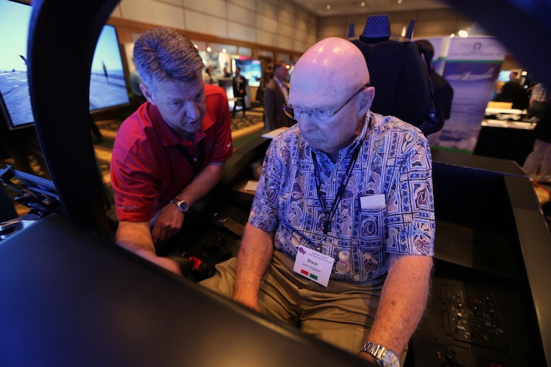 Mark Bosley, left, explains the controls of the Lockheed Martin  F-35 demonstrator to John Hudson during the 45th Annual Marine Corps Aviation Association Symposium and Marine Aviation Summit at New Bern, N.C., May 17, 2016. Hundreds of naval aviators gathered at the convention center for the opening brief to the weeklong event. Senior leaders gathered to discuss the future of Marine Corps aviation and the steps the Corps is taking to reach its set goals. Bosley is a Lockheed Martin F-35 demonstrator instructor pilot and Hudson is a retired U.S. Marine and award nominee at the event. (U.S. Marine Corps photo by Cpl. N.W. Huertas/Released)