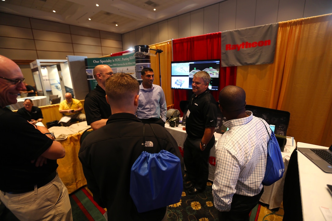Attendees interact with exhibits during the 45th Annual Marine Corps Aviation Association Symposium and Marine Aviation Summit at New Bern, N.C., May 17, 2016. Hundreds of naval aviators gathered at the convention center for the opening brief to the weeklong event. Senior leaders gathered to discuss the future of Marine Corps aviation and the steps the Corps is taking to reach its set goals. (U.S. Marine Corps photo by Cpl. N.W. Huertas/Released)