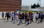 Defense Logistics Agency Troop Support Commander Army Brig. Gen. Charles Hamilton (left in black Army PT uniform) leads a group of participants at the second annual Federally Employed Women's 5K Walk/Run May 25. Hamilton encouraged employees to participate as part of DLA's resilience program.