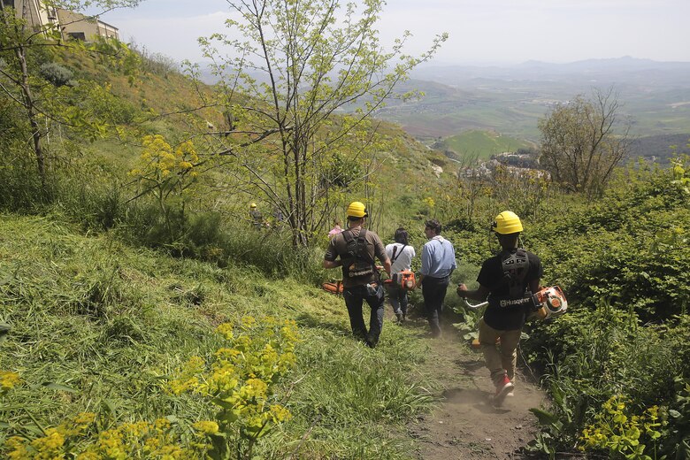 Marines with Special Purpose Marine Air-Ground Task Force Crisis Response-Africa Logistics Combat Element head down an overgrown path to cut grass at Castello di Lombardia in Enna, Sicily, during a community relations project on April 22, 2016.  Marines assist local areas in various projects to build relationships with the Sicilian government and people.  (U.S. Marine Corps photo by Cpl. Alexander Mitchell/released)