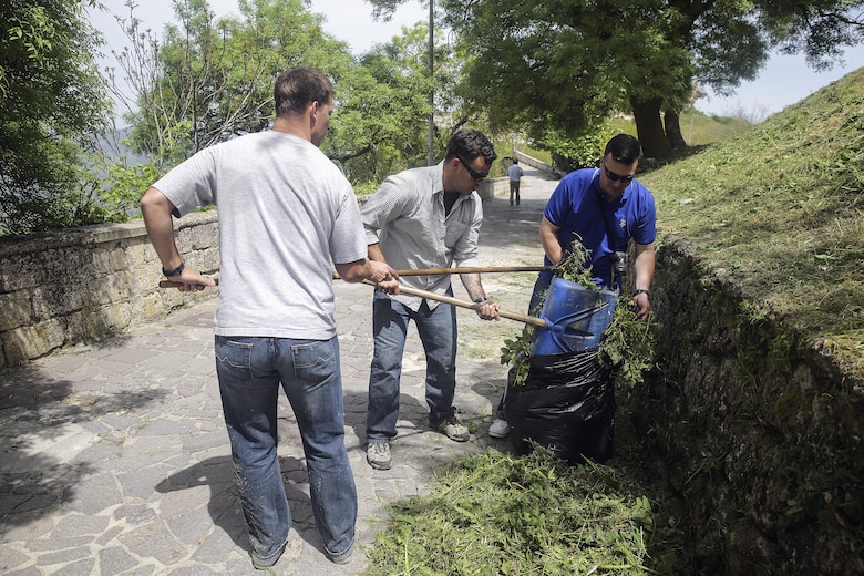 Marines with Special Purpose Marine Air-Ground Task Force Crisis Response-Africa Logistics Combat Element , clean up cut grass and garbage on a path at Castello di Lombardia in Enna, Sicily, during a community relations project on April 22, 2016.  Marines assist local areas in various projects to build relationships with the Sicilian government and people.  (U.S. Marine Corps photo by Cpl. Alexander Mitchell/released)