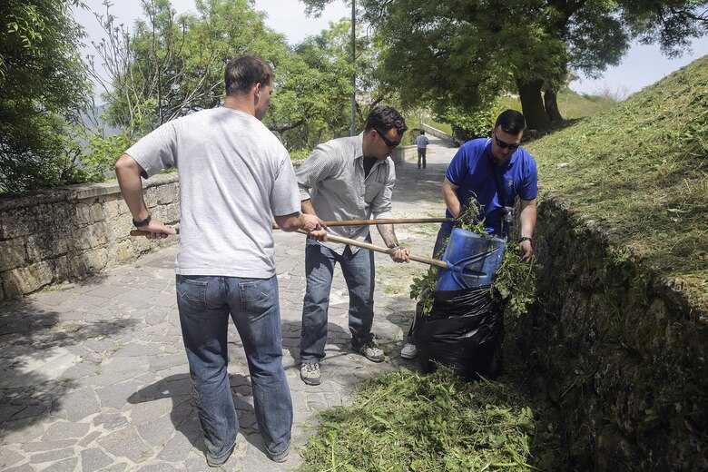 Marines with Special Purpose Marine Air-Ground Task Force Crisis Response-Africa Logistics Combat Element , clean up cut grass and garbage on a path at Castello di Lombardia in Enna, Sicily, during a community relations project on April 22, 2016.  Marines assist local areas in various projects to build relationships with the Sicilian government and people.  (U.S. Marine Corps photo by Cpl. Alexander Mitchell/released)