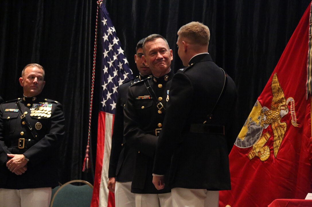Lt. Gen. John M. Davis, right, Deputy Commandant for Aviation, congratulates a Marine on stage during a winging ceremony at New Bern, N.C., May 19, 2016. Naval aviators received the prestigious honor of receiving an iconic emblem, depicting the culmination of years of training, perseverance and sacrifice. Pilots and crewmen receive wings once they complete their respective training requirements and are then designated to join the fleet as an operational Marine Corps asset. The winging ceremony took place during the 45th Annual Marine Corps Aviation Association Symposium and Marine Corps Aviation Summit. ( U.S. Marine Corps photo by Cpl. N.W. Huertas/ Released)