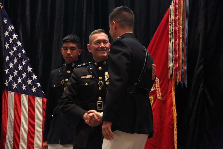 Lt. Gen. John M. Davis, right, Deputy Commandant for Aviation, congratulates a Marine on stage during a winging ceremony at New Bern, N.C., May 19, 2016. Naval aviators received the prestigious honor of receiving an iconic emblem, depicting the culmination of years of training, perseverance and sacrifice. Pilots and crewmen receive wings once they complete their respective training requirements and are then designated to join the fleet as an operational Marine Corps asset. The winging ceremony took place during the 45th Annual Marine Corps Aviation Association Symposium and Marine Corps Aviation Summit. ( U.S. Marine Corps photo by Cpl. N.W. Huertas/ Released)