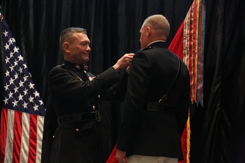 Lt. Gen. John M. Davis, right, Deputy Commandant for Aviation, pins wings on a Marine on stage during a winging ceremony at New Bern, N.C., May 19, 2016. Naval aviators received the prestigious honor of receiving an iconic emblem, depicting the culmination of years of training, perseverance and sacrifice. Pilots and crewmen receive wings once they complete their respective training requirements and are then designated to join the fleet as an operational Marine Corps asset. The winging ceremony took place during the 45th Annual Marine Corps Aviation Association Symposium and Marine Corps Aviation Summit. ( U.S. Marine Corps photo by Cpl. N.W. Huertas/ Released)