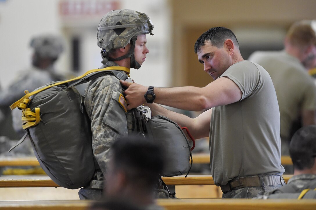 A paratrooper undergoes an inspection of his chute and gear before a joint airborne and air transportability training exercise at Joint Base Elmendorf-Richardson, Alaska, May 19, 2016. Air Force photo by Alejandro Pena