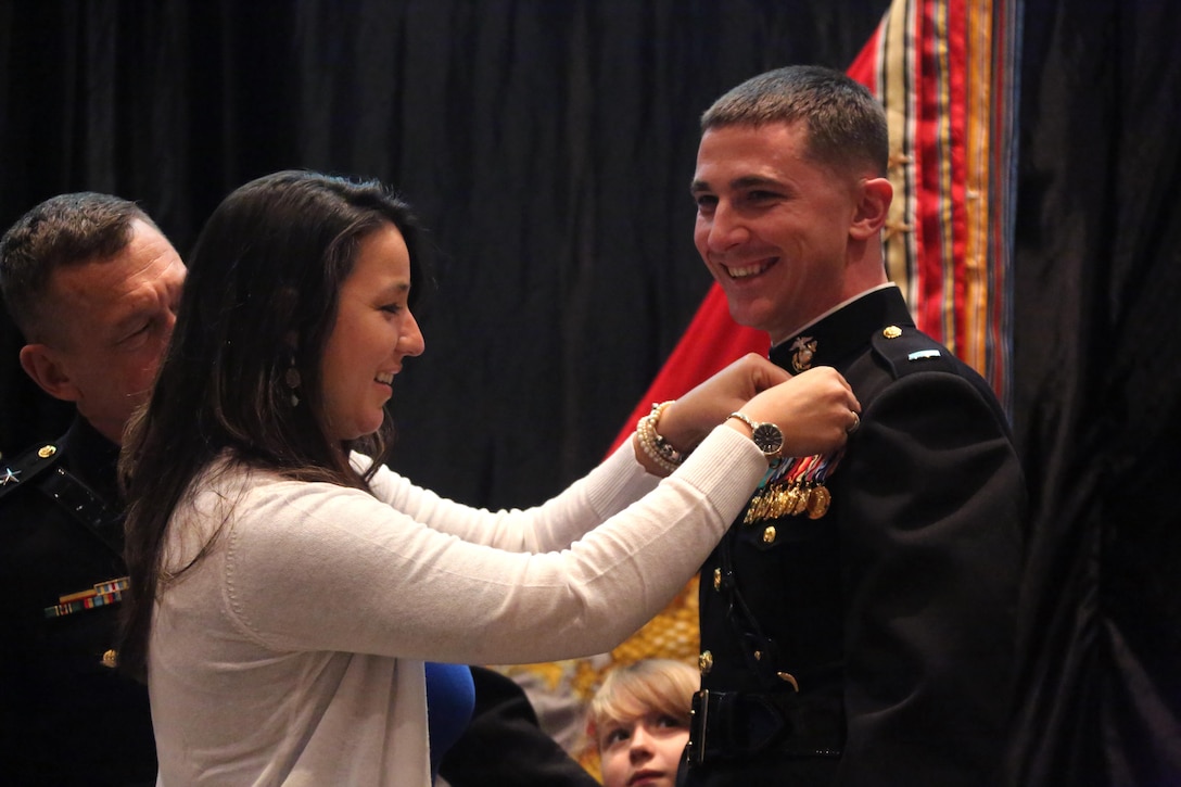 A Marine Corps aviator is pinned by his wife during a winging ceremony at New Bern, N.C., May 19, 2016. Naval aviators received the prestigious honor of receiving an iconic emblem, depicting the culmination of years of training, perseverance and sacrifice. Pilots and crewmen receive wings once they complete their respective training requirements and are then designated to join the fleet as an operational Marine Corps asset. The winging ceremony took place during the 45th Annual Marine Corps Aviation Association Symposium and Marine Corps Aviation Summit. (U.S. Marine Corps photo by Cpl. N.W. Huertas/ Released)