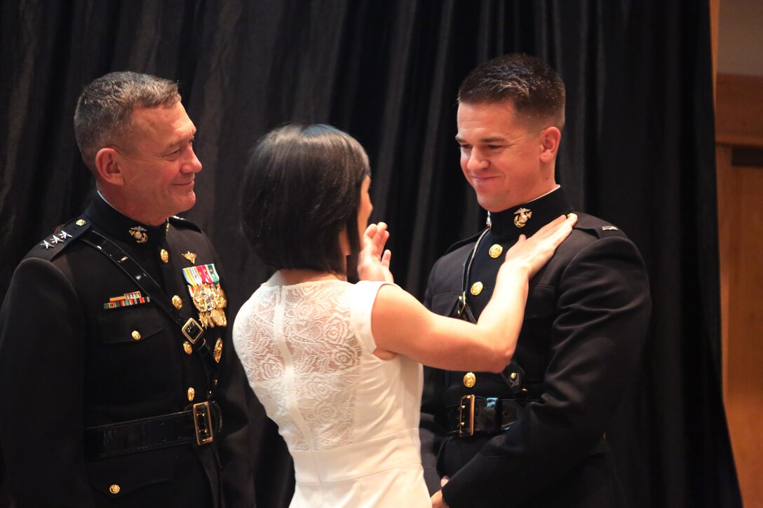 A Marine Corps aviator is pinned by his wife during a winging ceremony at New Bern, N.C., May 19, 2016. Naval aviators received the prestigious honor of receiving an iconic emblem, depicting the culmination of years of training, perseverance and sacrifice. Pilots and crewmen receive wings once they complete their respective training requirements and are then designated to join the fleet as an operational Marine Corps asset. The winging ceremony took place during the 45th Annual Marine Corps Aviation Association Symposium and Marine Corps Aviation Summit. (U.S. Marine Corps photo by Cpl. N.W. Huertas/ Released)