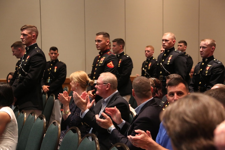 Young aviators stand for applause during a winging ceremony at New Bern, N.C., May 19, 2016. Naval aviators received the prestigious honor of receiving an iconic emblem, depicting the culmination of years of training, perseverance and sacrifice. Pilots and crewmen receive wings once they complete their respective training requirements and are then designated to join the fleet as an operational Marine Corps asset. The winging ceremony took place during the 45th Annual Marine Corps Aviation Association Symposium and Marine Corps Aviation Summit. ( U.S. Marine Corps photo by Cpl. N.W. Huertas/ Released)