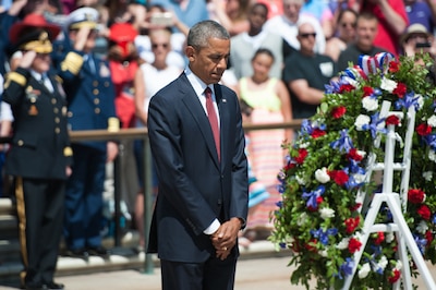 President Barack Obama bowing his head after laying a wreath at the Tomb of the Unknown Soldier.